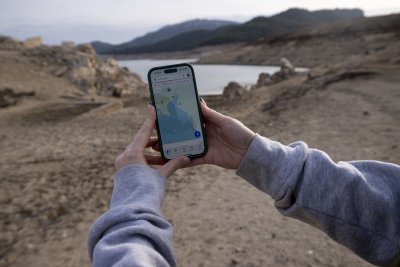 A person shows the map on the phone at the Darnius-Boadella swamp, on the Muga river, one of the clearest examples of lack of water in the Mediterranean region.