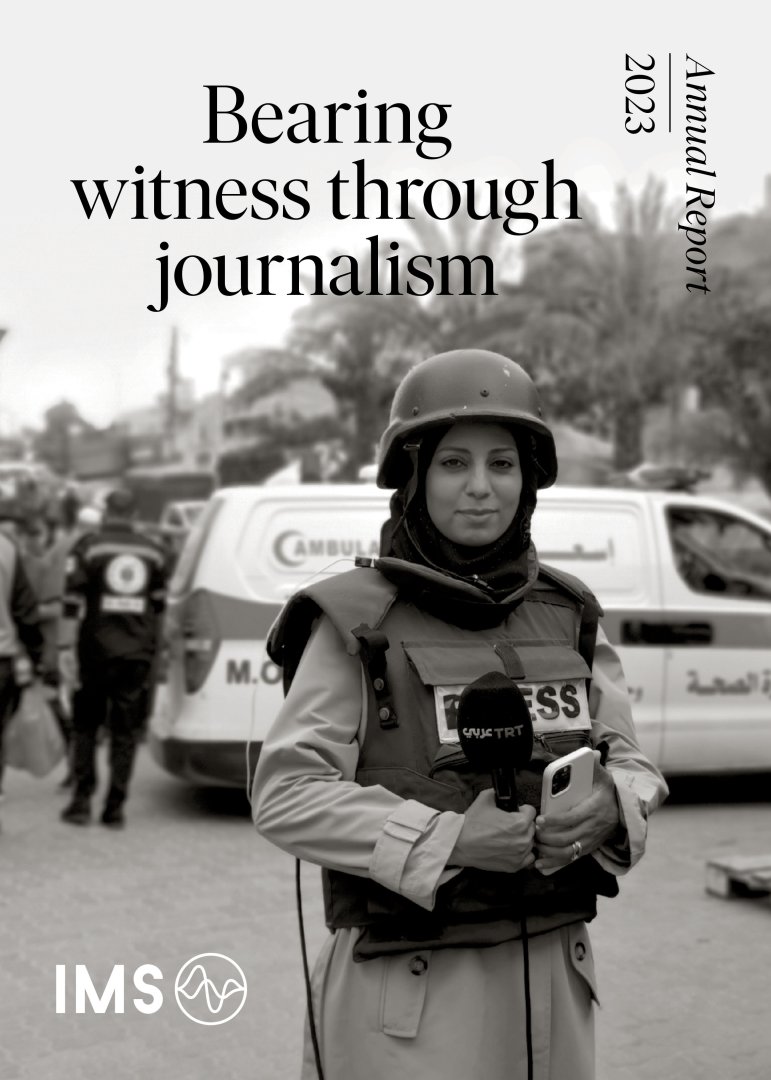 The cover IMS annual report 2023 showing a woman journalist from Gaza holding a microphone and wearing safety gear.