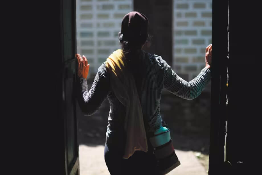 A woman photographed in a doorway from behind. Photo by Gustavo Torrijos for El Espectador.